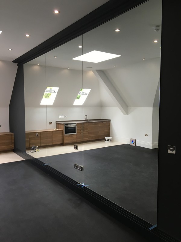 Frameless glass partition in loft conversion by Dunstable glaziers